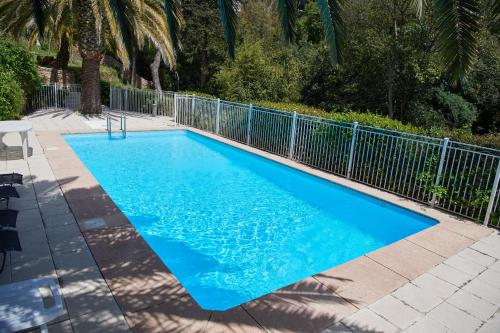 une piscine bleue avec une clôture métallique dans l'établissement Appartement Luxueux 150m2 - Cannes, à Cannes