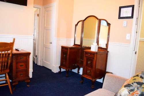 a room with a dresser with a mirror and a bed at Grand Imperial Hotel in Silverton