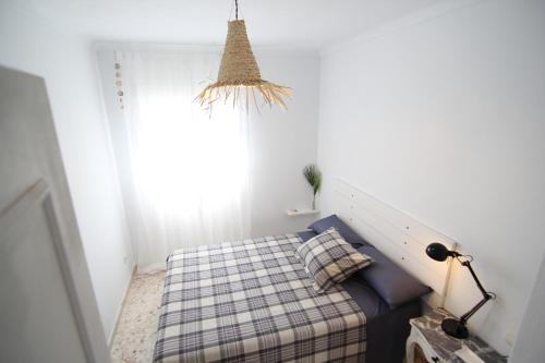 a small bedroom with a bed and a window at Alojamiento Armenia Piscina in Alcalá de los Gazules
