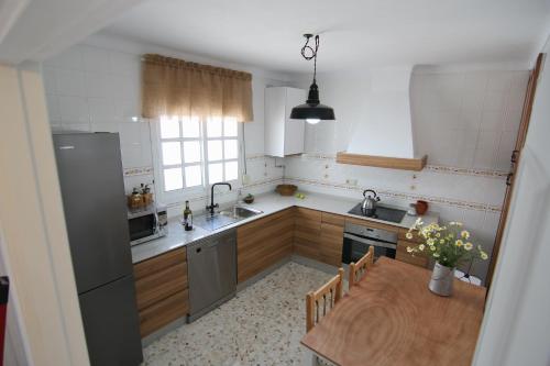 a kitchen with a wooden table and a dining room at Alojamiento Armenia Piscina in Alcalá de los Gazules