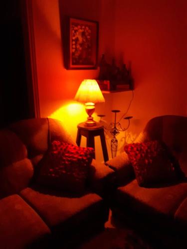 a living room with a couch and a table with a lamp at Cana Wedding Guest House in Kafr Kannā