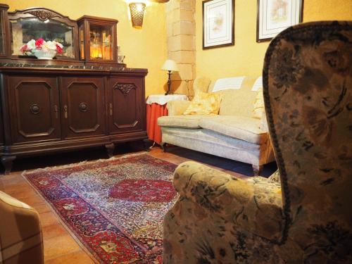 a living room with a couch and a chair at Mas Cal Sastre in Sant Hilari Sacalm
