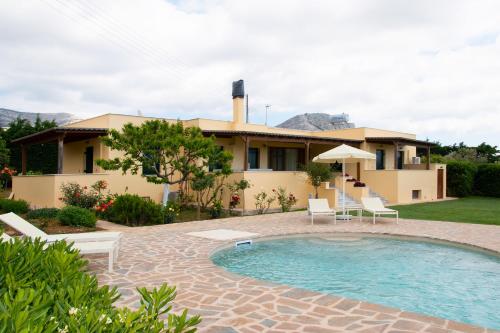 uma villa com uma piscina e uma casa em Naxos Cottage em Káto Sangríon