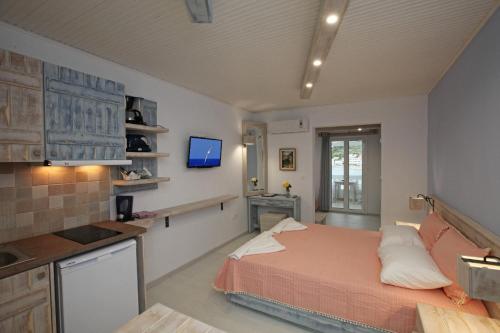 um quarto com uma cama e uma cozinha com uma televisão em Bella Vista em Batsi