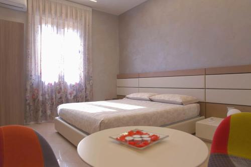 a bedroom with a bed and a table with a tray of strawberries at Luxury B&B Coccolhouse in San Cesario di Lecce