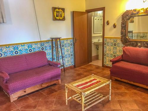 een woonkamer met 2 banken en een tafel bij VILLA VENERE in San Vito lo Capo