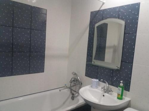 een badkamer met een wastafel, een toilet en een spiegel bij Apartment Akademika Krilova 7 in Sevastopol