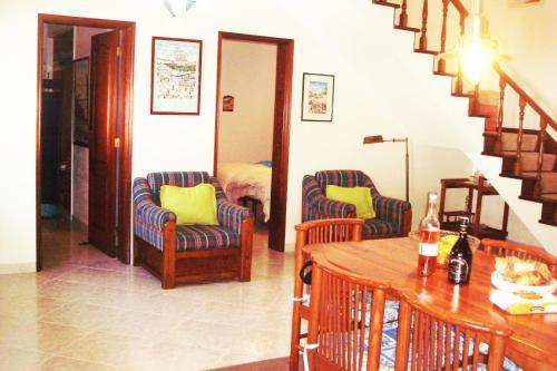 Una sala de estar con dos sillas y una mesa. en Campo de Oleandros, en Lourinhã