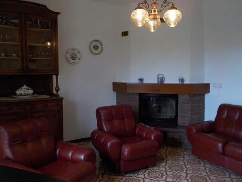 a living room with two chairs and a fireplace at Casa Romme in Tornolo