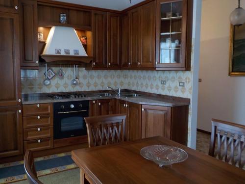 a kitchen with wooden cabinets and a wooden dining table at Casa Romme in Tornolo
