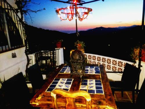 a table on a balcony with a view of the mountains at Venta Real 12v in Cómpeta