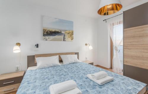 een slaapkamer met een blauw bed met 2 witte kussens bij Villa Zlata in Krk