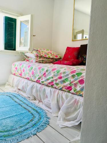 a bed in a room with a mirror and a rug at Pangiotas Pencione in Karpathos