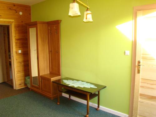 a room with a table and a green wall at Pensjonat Dworek Baranówka in Goniadz