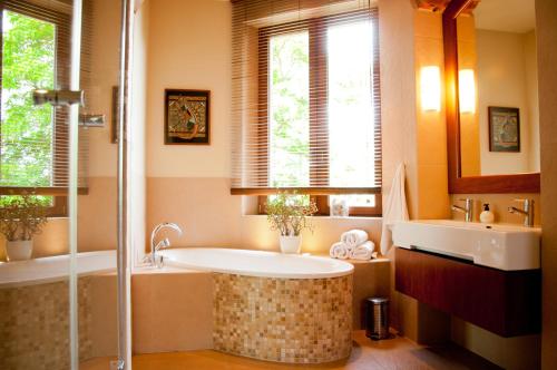 a bathroom with a tub and a sink at Apartamenty 23 in Poznań