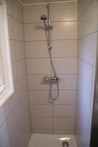 a shower with a shower head in a bathroom at t'Bakkersboschje nummer 8 in Putten