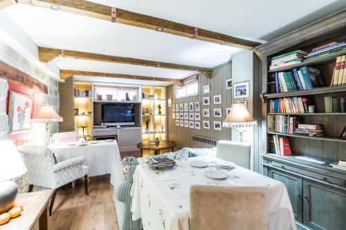 a living room with a table and chairs and books at B&B Concha in Becerril de la Sierra