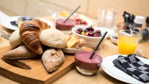 a table with a plate of bread and a bowl of fruit at B&B 4 Seasons in Riemst