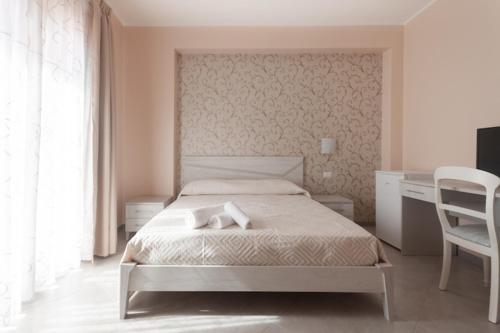 a bedroom with a bed and a desk and a chair at L'AURORA in Piedimonte Etneo