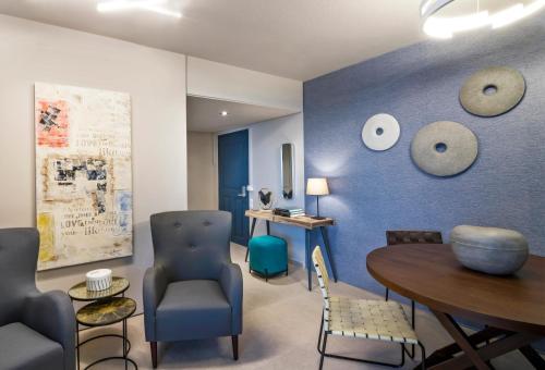 a room with a blue wall with a table and chairs at Marina Alimos Hotel Apartments in Athens