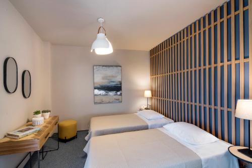 a bedroom with two beds and a desk and a bed sidx sidx sidx at Marina Alimos Hotel Apartments in Athens