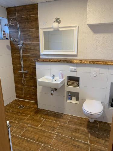 a bathroom with a toilet and a sink and a shower at Gemütliche Heide-Ferienwohnung in Soltau