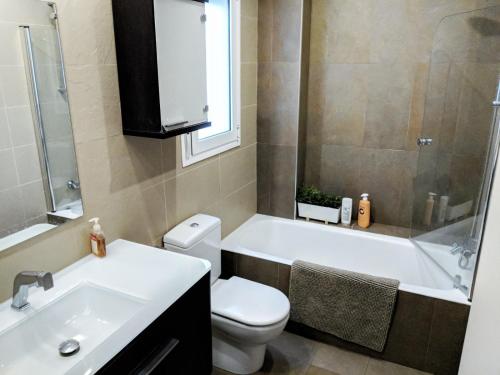 a bathroom with a toilet and a tub and a sink at Dos Torres Puerta del Carmen - Moderno y Espacioso en el Centro in Zaragoza