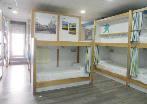 a room with three bunk beds in it at Albergue Corredoiras in Padrón