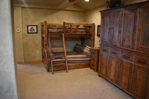 a bedroom with two bunk beds and a wooden cabinet at Cougar Ridge Resort in Torrey