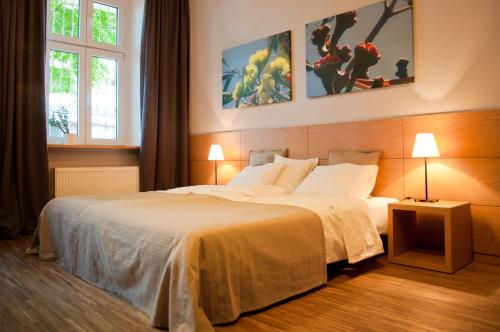 a hotel room with two beds and two lamps at Apartamenty 23 in Poznań