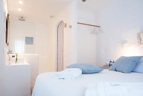 a white room with a bed and a sink at HOTEL ANHEL in Ferreries