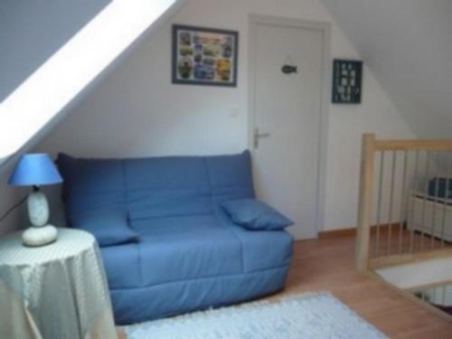 a blue couch in a living room with a staircase at Maison Molène, au Pays des Abers Plouguerneau in Plouguerneau