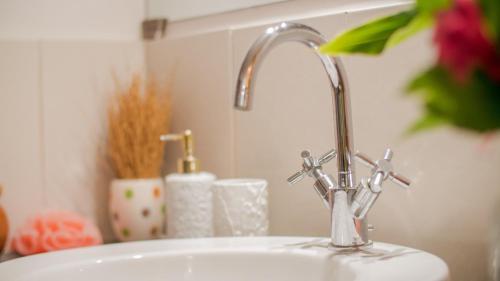 a sink with a faucet in a bathroom at MADIROKELY HOUSE Nosy Be in Ambatoloaka