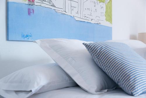 a bed with two white pillows and a blue wall at HOTEL ANHEL in Ferreries