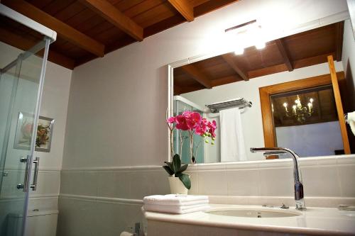 a bathroom with a sink and a vase of flowers at Hotel Emblemático San Agustin in Icod de los Vinos