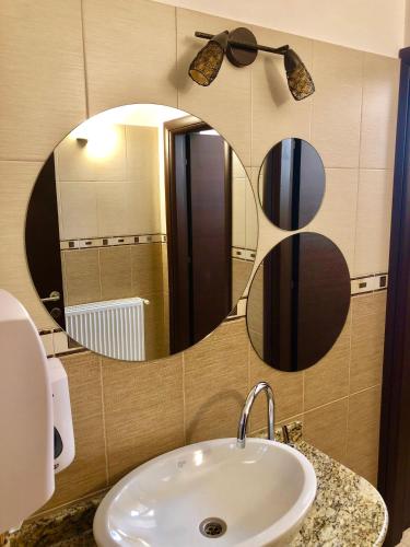 a bathroom with a sink and a mirror at Casa Muntenească Alessandro in Piteşti
