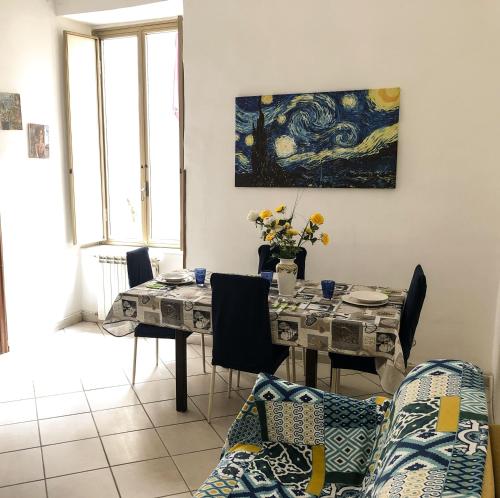 una sala da pranzo con tavolo, sedie e un quadro di ANDREA'S HOUSE a Napoli