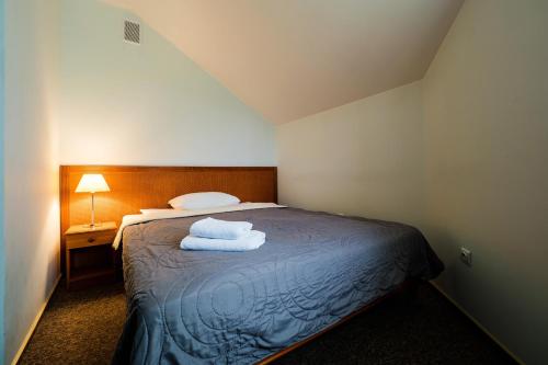 a bedroom with a bed with towels on it at Extrans in Olchowa