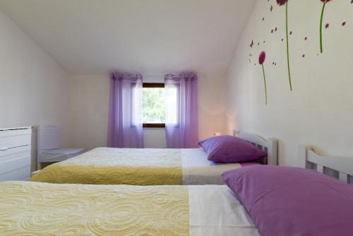 a bedroom with two beds and a window with purple curtains at Apartment Lordanic Zaglav, Dugi otok in Zaglav