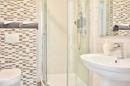 a bathroom with a shower and a sink and a toilet at Studio Apartment Ferias - Villa Nehaj in Senj