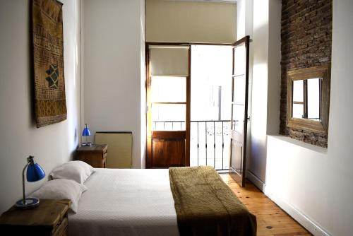 a bedroom with a bed and a large window at BA Stop Hotel House in Buenos Aires