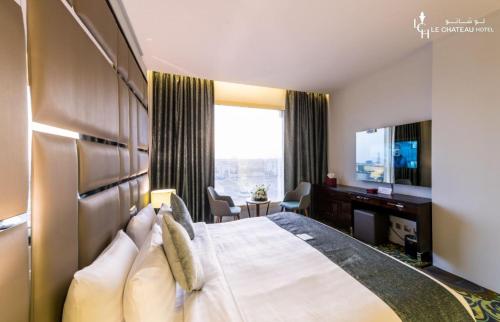 a hotel room with a bed and a desk and a television at LeChateau Boutique Hotel in Jeddah