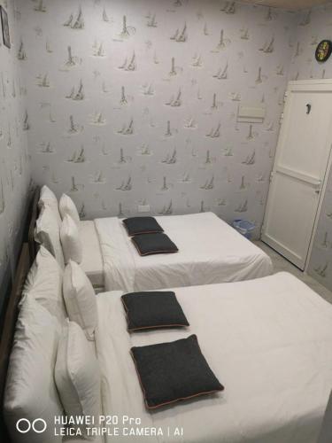 two beds in a small room with white walls at Happiness Farm in Hatta
