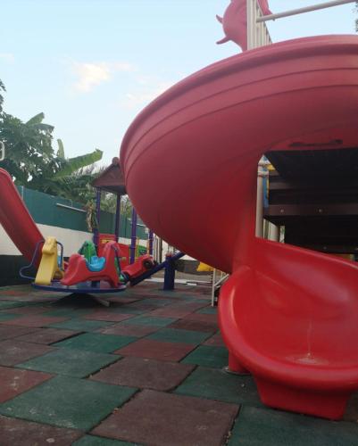 a playground with a red toilet and a slide at Happiness Farm in Hatta