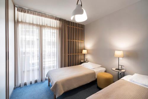a hotel room with two beds and a window at Marina Alimos Hotel Apartments in Athens