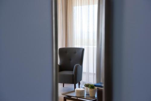 a black chair sitting in front of a window at Marina Alimos Hotel Apartments in Athens