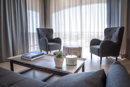 a living room with a couch and two chairs and a table at Marina Alimos Hotel Apartments in Athens