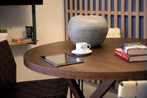 a table with a coffee cup and books on it at Marina Alimos Hotel Apartments in Athens