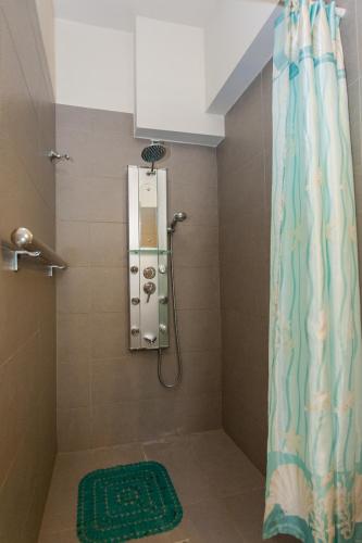 a shower with a green rug next to a shower curtain at Cretamos Seaside Villas in Kissamos