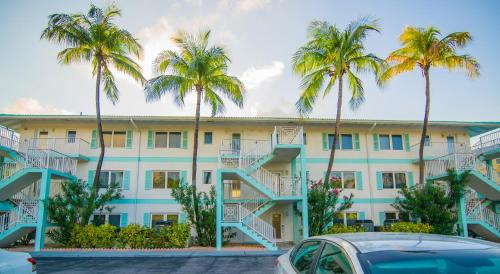 a building with palm trees in front of it at Seven Mile Beach Resort in George Town